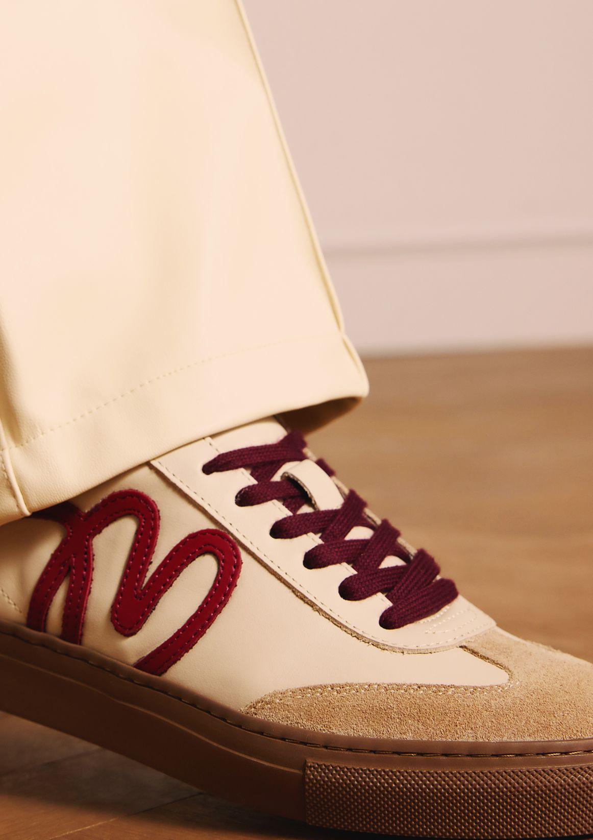 Beigefarbene Ledersneaker mit bordeauxroten Details