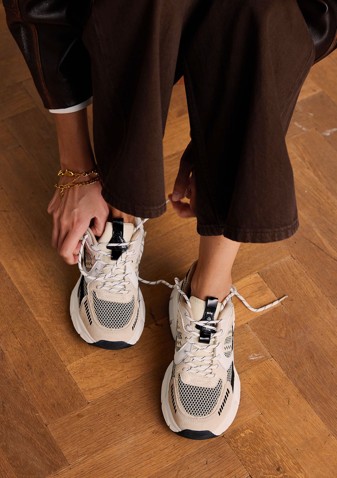 Beige sneakers met zwarte en witte mesh details