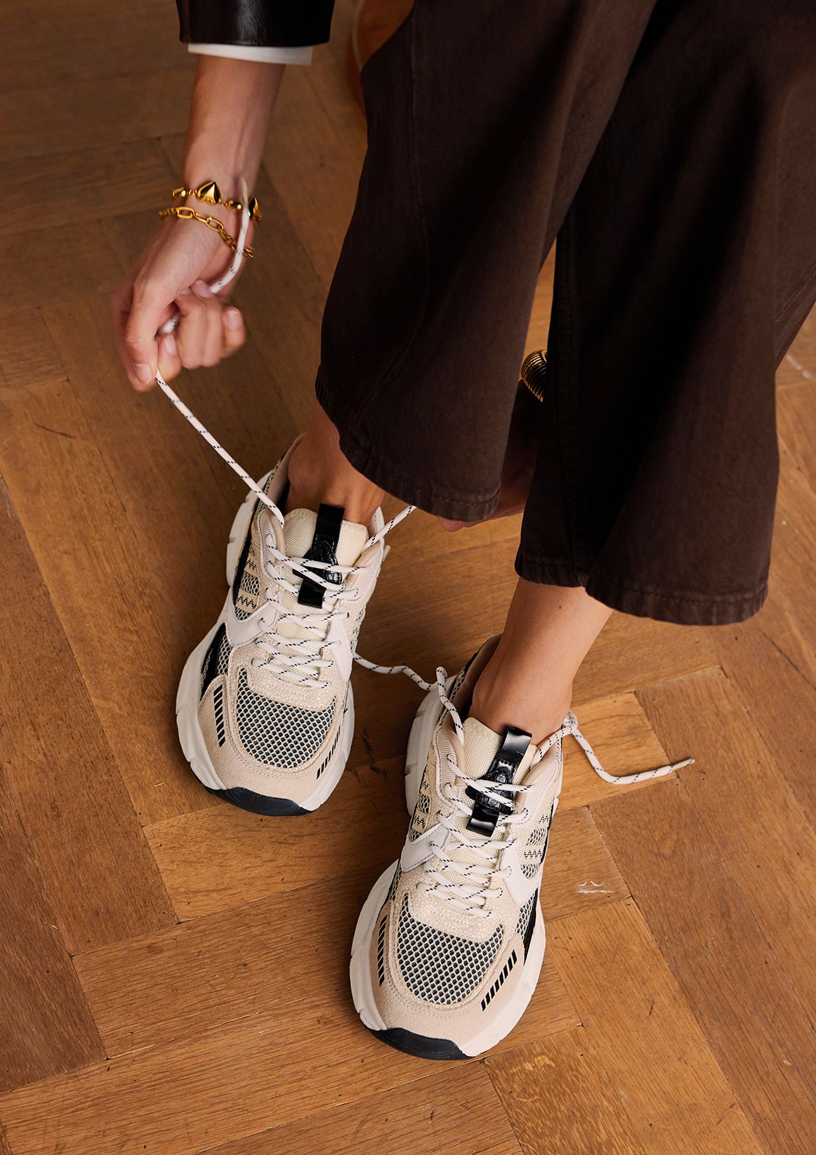 Beige sneakers met zwarte en witte mesh details
