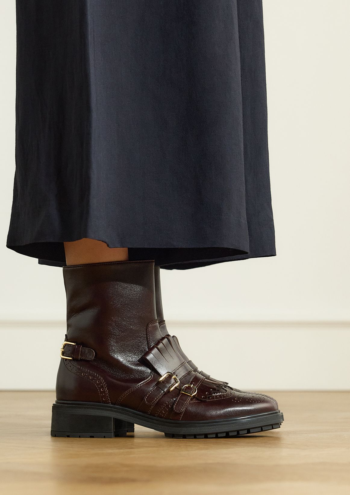 Dunkelbraune Lederstiefeletten mit goldfarbenen Schnallen