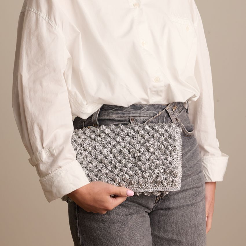 Silberfarbene Clutch mit gewebten Details
