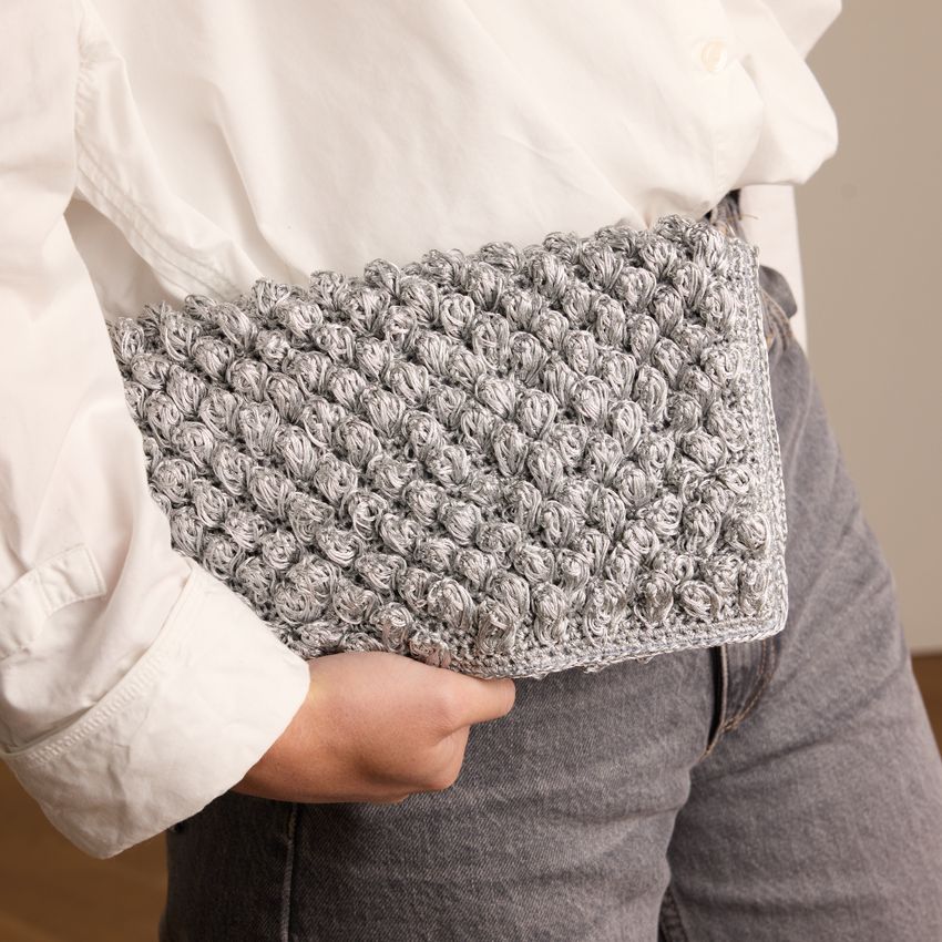 Silberfarbene Clutch mit gewebten Details