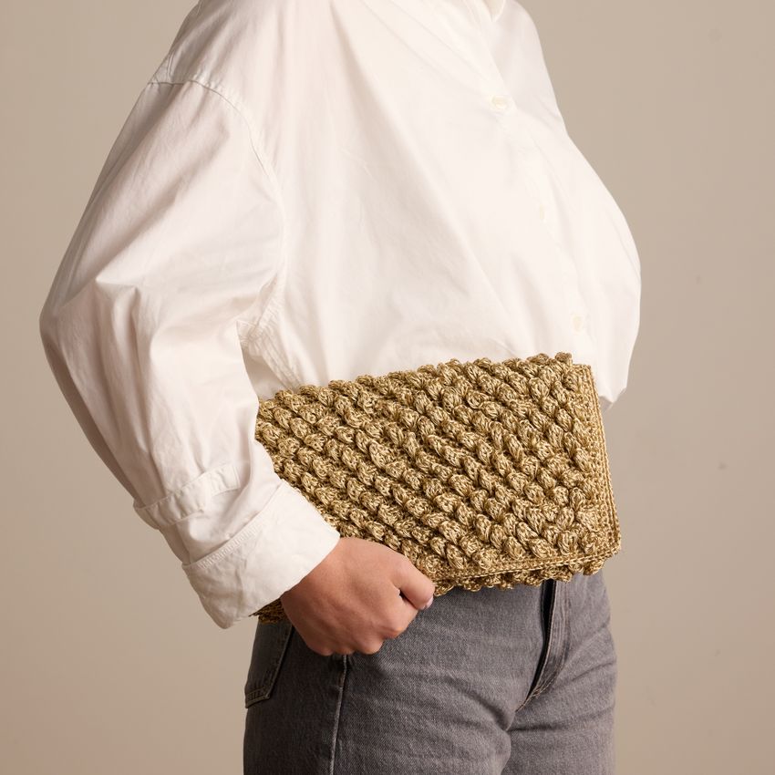 Gouden clutch met gebreide details