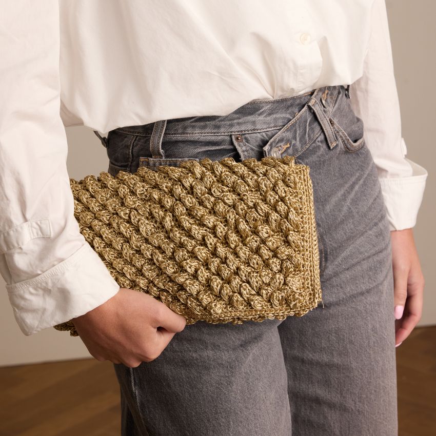 Gouden clutch met gebreide details